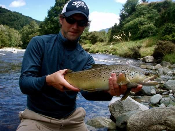 Adam displays a catch along the Rangitaiki River in Taupō, New Zealand, where he spent several weeks fishing before starting law school.